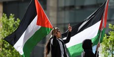 Deux personnes brandissent des drapeaux palestiniens