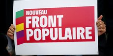 Une personne tient une pancarte avec le logo du Nouveau Front Populaire (NFP)