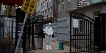 Un agent de prevention des epidemies monte la garde a l'entree d'un complexe residentiel a pekin, en chine