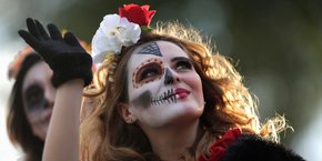 « Homme augmenté », « transhumanisme »... les promesses d'allongement de la vie que font miroiter les gourous de la tech renvoient à deux questions qui ont toutes le même sous-jacent : notre rapport à la mort. (Photo d'illustration : une femme déguisée en Catrina, figure emblématique de la Fête des Morts - le Dia de muertos -, salue lors d'un défilé précédant le jour des morts à Monterrey, au Mexique, le 27 octobre 2019.