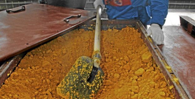 A worker rakes uranium oxide after the opening ceremony of the Zarechnoye mine in southern Kazakhstan December 7, 2006. Zarechnoye, a joint venture between Russia and Kazakhstan, produced its first tonne of uranium in Kazakhstan on Thursday in a move that helps Russia secure cheap supplies of the ra