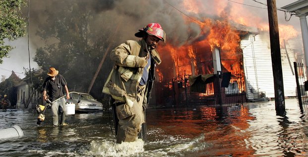 La Nouvelle-Orléans sous les eaux après Katrina, le 31 août 2005. Un pompier aide un homme à sortir des eaux.