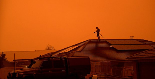 Feux en Australie : un homme utilise un tuyau d'arrosage pour mouiller sa maison