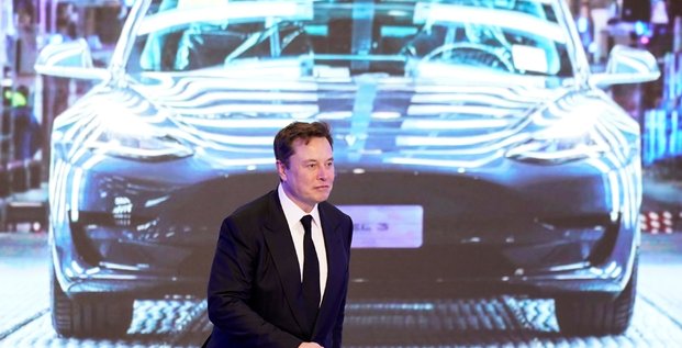 Elon Musk, patron de Tesla, devant un écran montrant une Tesla Model 3, lors de la cérémonie d'ouverture du programme Model Y de Tesla en Chine à Shanghai