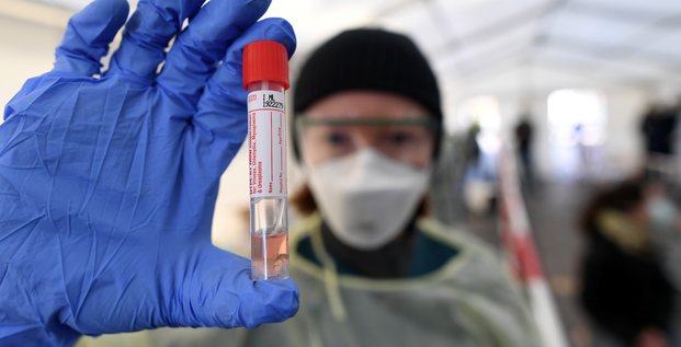 Covid-19 / Coronavirus : Un personnel médical présente un prélèvement pris dans un centre de tests, à Munich, en Allemagne