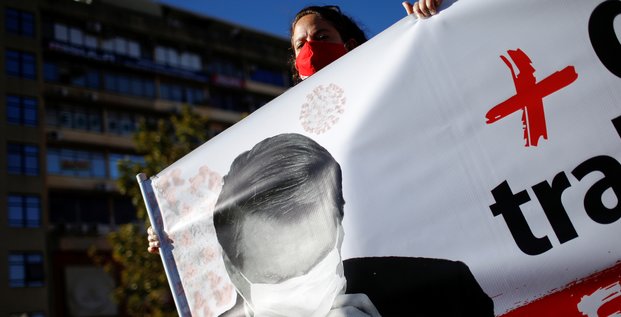 Brésil : une manifestante tient une bannière montrant le président Jair Bolsonaro durant une manifestation contre lui et en honneur aux victimes du coronavirus, le 7 août 2020
