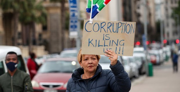 Afrique du Sud : une manifestante tient une pancarte disant La corruption tue à Cape Town le 5 septembre 2020