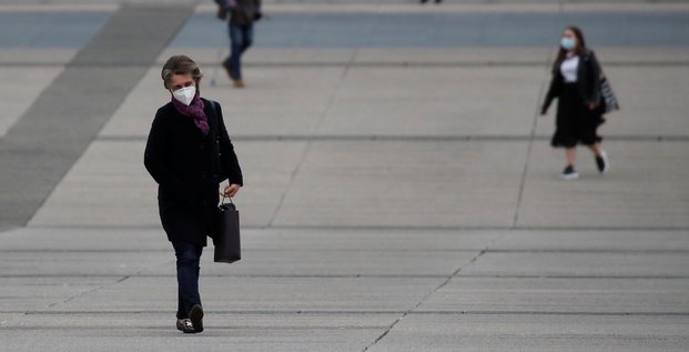 Coronavirus : une femme portant un masque marche dans le quartier La Défense à Paris