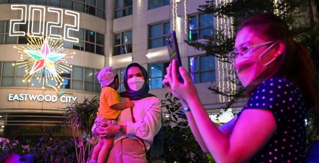 Une femme et un enfant posent pour une photo lors de la célébration du Nouvel An à Eastwood Mall, à Quezon City, aux Philippines, le 1er janvier 2022.