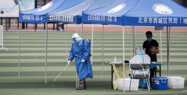 Pékin, Chine, coronavirus : un homme en tenue de protection diffuse du désinfectant au Guangan Sport Center