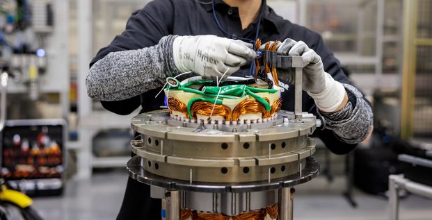 Une opératrice monte un moteur électrique de nouvelle génération à l'usine Renault de Cléon.