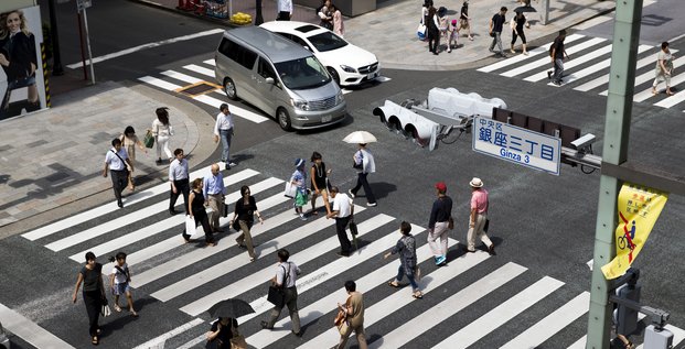 Des personnes traversent une rue dans le quartier de ginza a tokyo, au japon
