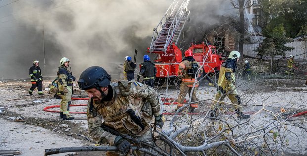 Des pompiers aident a evacuer un immeuble detruit par une frappe de drone russe a kyiv, en ukraine