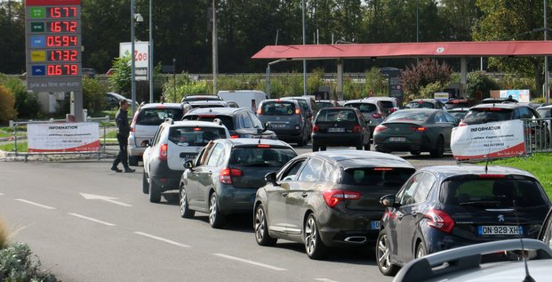 Des automobilistes font la queue pour remplir leur reservoir d'essence aux pompes de la station-service auchan de petite-foret