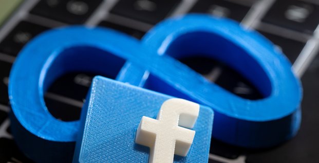 Une impression 3d du nouveau logo de facebook meta et le logo de facebook sont places sur le clavier d'un ordinateur portable dans cette illustration