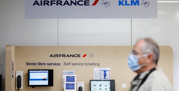 Un passager passe devant les logos air france et klm a l'aeroport de nantes-atlantique en france