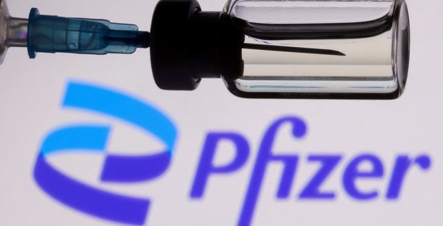 Photo d'illustration d'une seringue devant le logo de pfizer