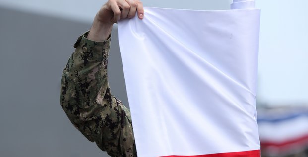 Un soldat americain deroule un drapeau de la pologne, a gdynia