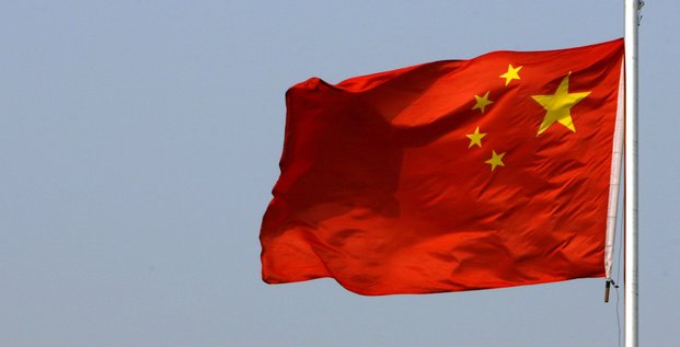 Un drapeau chinois flotte devant la grande muraille de chine, situee au nord de pekin