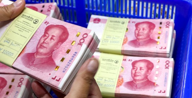 Un employe de banque compte les billets en renminbi (rmb) ou yuan de la chine a cote des billets en dollars americains dans une kasikornbank a bangkok