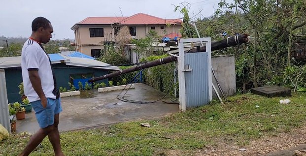 Un homme marche a cote d'un poteau tombe apres le passage du cyclone kevin, a port vila
