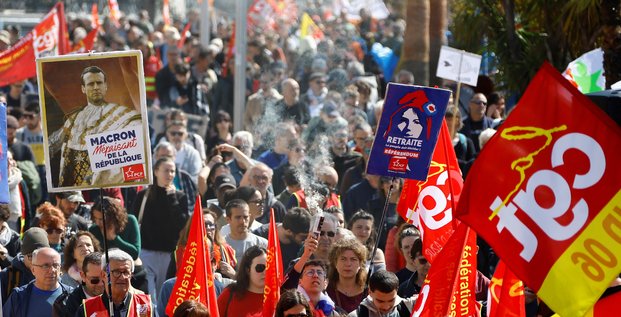 Des manifestants du syndicat cgt tiennent une pancarte representant le president francais emmanuel macron