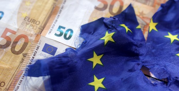 Des billets de banque en euros et un drapeau europeen dechire