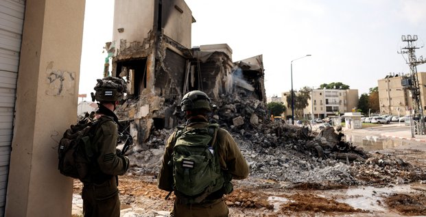 Les soldats israeliens regardent les restes d'un poste de police a sderot, en israel