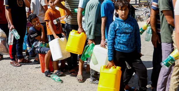 Des palestiniens font la queue pour remplir des bidons de carburant a gaza