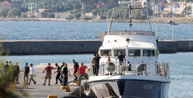 Des migrants secourus debarquent d'un navire au port de mytilene
