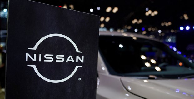 Un logo nissan a cote d'un vehicule lors du salon international de l'automobile de new york