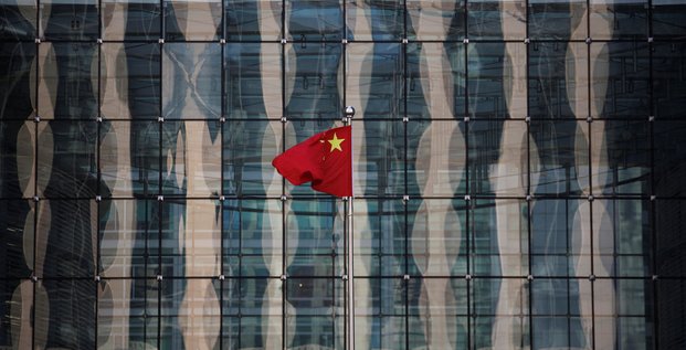 Un drapeau national chinois flotte devant le siege d'une banque commerciale