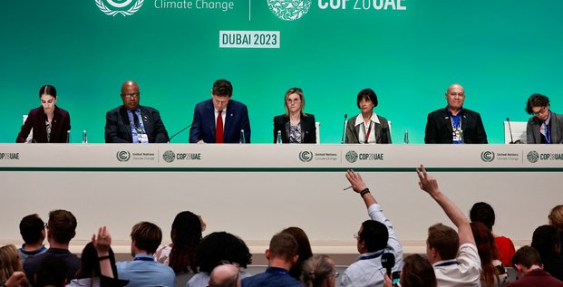 Des personnes levent la main pendant une conference de presse, lors de la conference des nations unies sur le changement climatique (cop28), a dubai