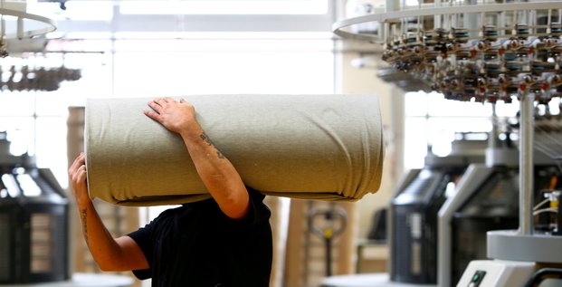 Un employe deplace des draperies dans l'usine de l'entreprise textile trigema a burladingen