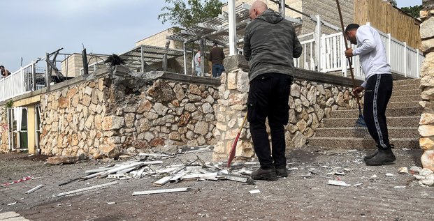 Des personnes travaillent sur le site ou une roquette a atterri apres un tir de roquette sur israel, dans le cadre des hostilites transfrontalieres entre le hezbollah et les forces israeliennes, a shlomi