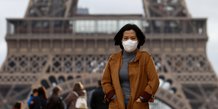 Coronavirus/Covid-19 : Une femme portant un masque marche sur l'esplanade du Trocadéro, devant la Tour Eiffel