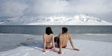 Les activistes du climat Lesley Butler et Rob Bell prennent un bain de soleil sur la banquise arctique norvégienne le 25 avril 2007