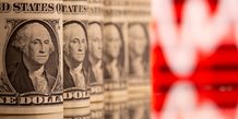 Photo d'illustration montrant des billets de banque americains d'un dollar devant un graphique boursier