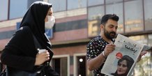 Un homme regarde un journal montrant mahsa amini, victime de la police des moeurs de la republique islamique d'iran, a teheran
