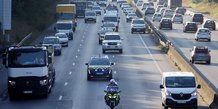 Un convoi de police et d'autres vehicules sur une autoroute pres de paris, france