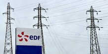 Le logo d'edf devant des lignes electriques de la centrale nucleaire du tricastin a saint-paul-trois-chateaux, france