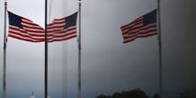 Le capitole des etats-unis et les drapeaux americains se refletent dans une fenetre a washington