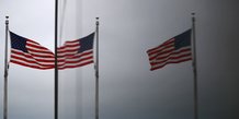 Le capitole des etats-unis et les drapeaux americains se refletent dans une fenetre a washington
