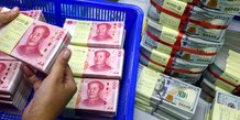 Un employe de banque compte les billets en renminbi (rmb) ou yuan de la chine a cote des billets en dollars americains dans une kasikornbank a bangkok