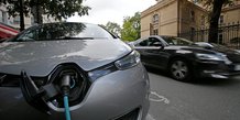 Une voiture electrique en train d'etre rechargee dans une rue de paris, en france