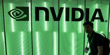 Une personne passe devant un logo nvidia